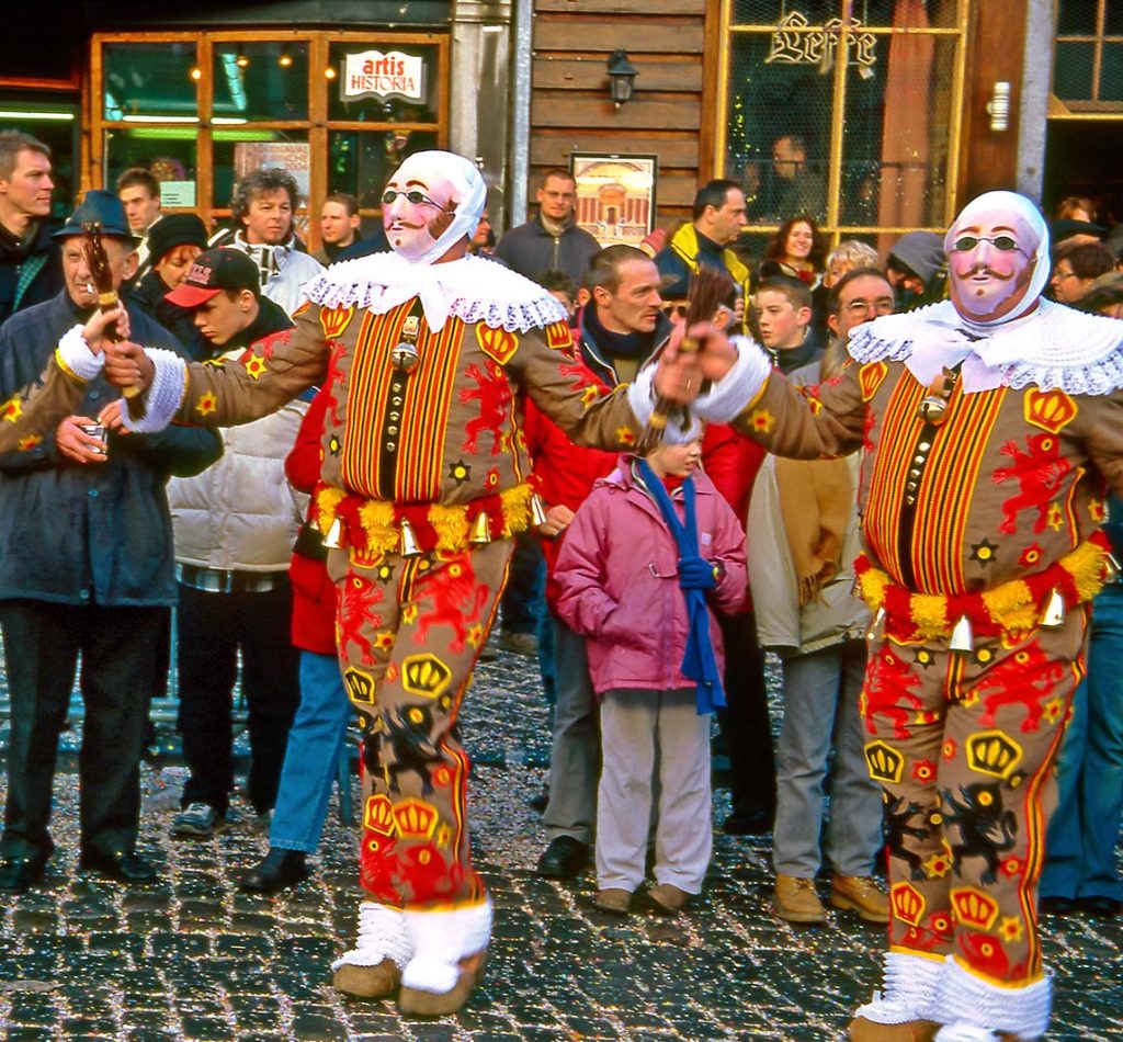 Men in traditional outfits dancing during the historic Binche Carnival parade in Belgium