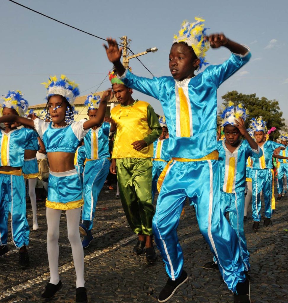 Children dancing in colorful costumes at CayMAS Carnival parade