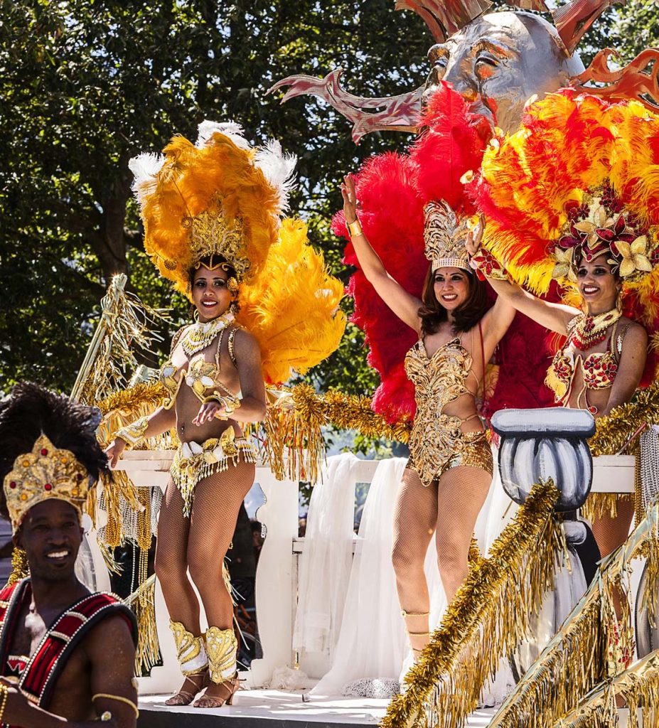 Group of women on a colorful float waving to the crowd at Charleston Carifest parade