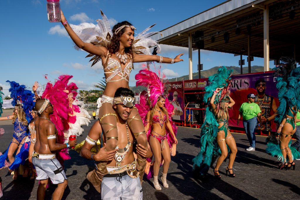 Couple in matching Carnival costumes playing chicken during the Tobago Carnival parade