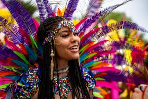 Close-up of a smiling woman in a colorful Carnival costume, featured in the blog “6 Reasons You Need to Experience the Magic of Carnival in 2025.”