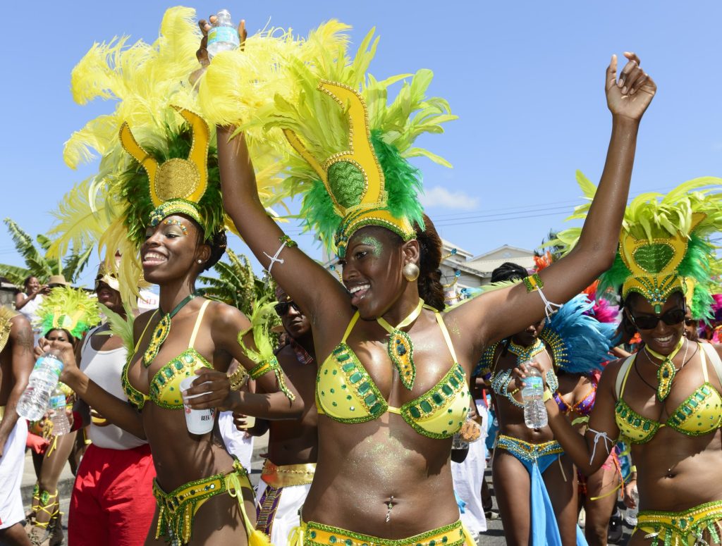 Women with their hands in the air celebrating carnival, featured in the blog “Experience the Carnival: The Food, Music, and Joy Awaiting You in 2025,” showcasing culture and festivity.