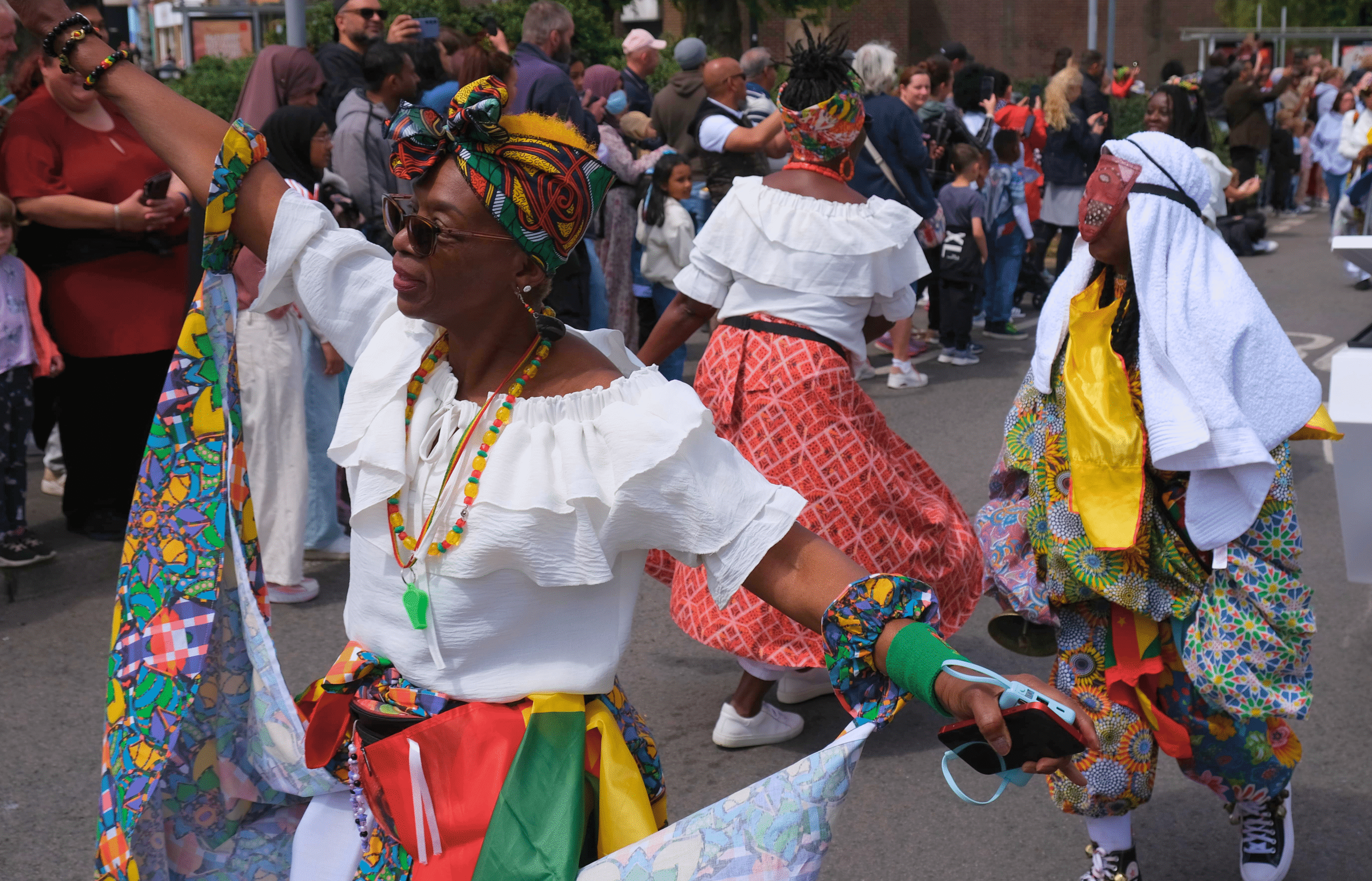 Women in traditional cultural wear dancing on the streets during the Luton International Carnival on May 25, 2025, celebrating diversity and heritage.