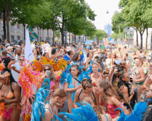 Overview of the Vienna Carnival crowd taken from the back of a truck during the Vienna Carnival Road March in July 2025, with revelers dancing in colorful costumes.