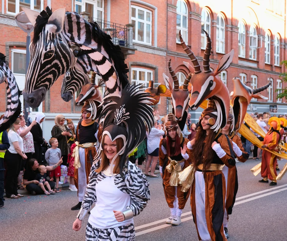 Participants wearing large animal headpieces and themed costumes during Aalborg Karneval street parade.