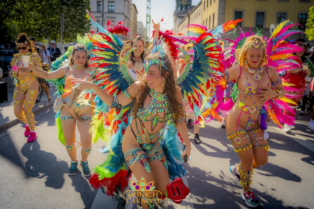 Colorful carnival dancers in feathered costumes performing during the Munich Carnival Road March in Munich, Germany.