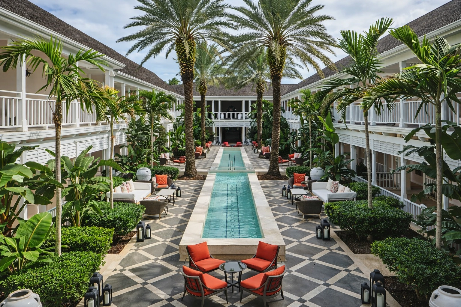 Luxury courtyard at Four Seasons Resort Bahamas featuring a symmetrical T-shaped reflective pool, palm trees, and elegant colonial balconies – best hotels & areas to stay in nassau.