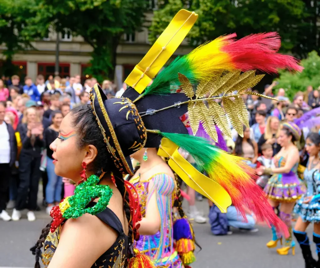 Performer in bright feathered costume at Berlin Carnival street parade in Berlin