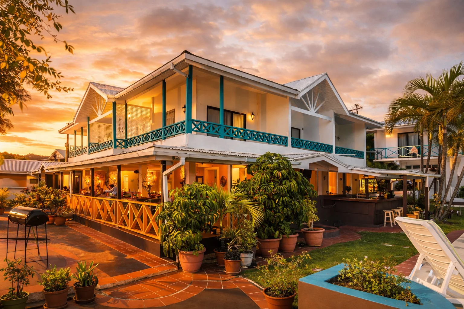 Mariners Hotel exterior with tropical landscaping and golden sunset lighting at VincyMas Hotels in St. Vincent.
