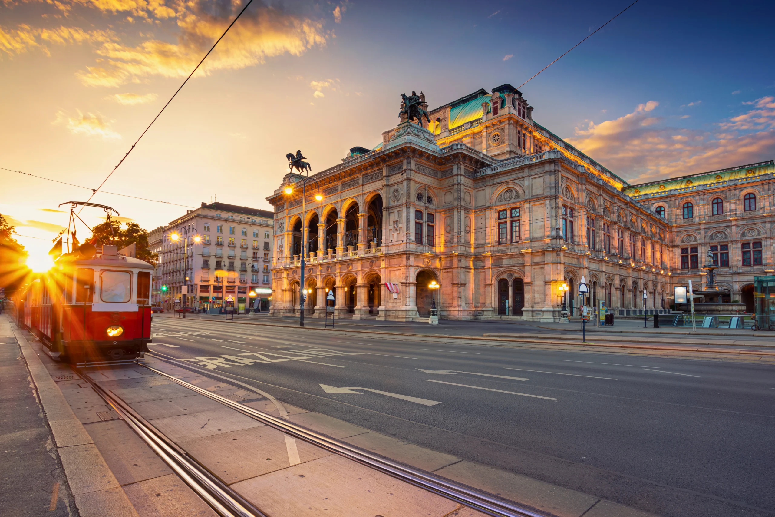 Historic red tram in central Vienna near the State Opera during sunset for Vienna Carnival travel