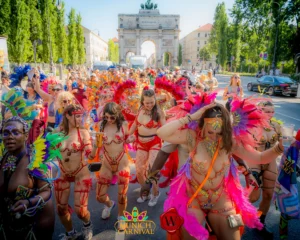 Crowd dancing in colorful feather costumes during Munich Carnival street parade, vibrant carnival atmosphere with masqueraders and festival energy