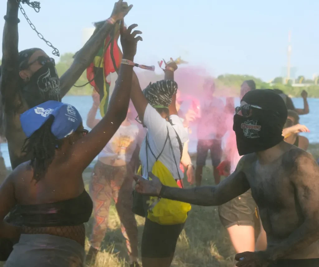 Crowd throwing colorful powder and waving flags at Misbehave J’ouvert during Vienna Carnival