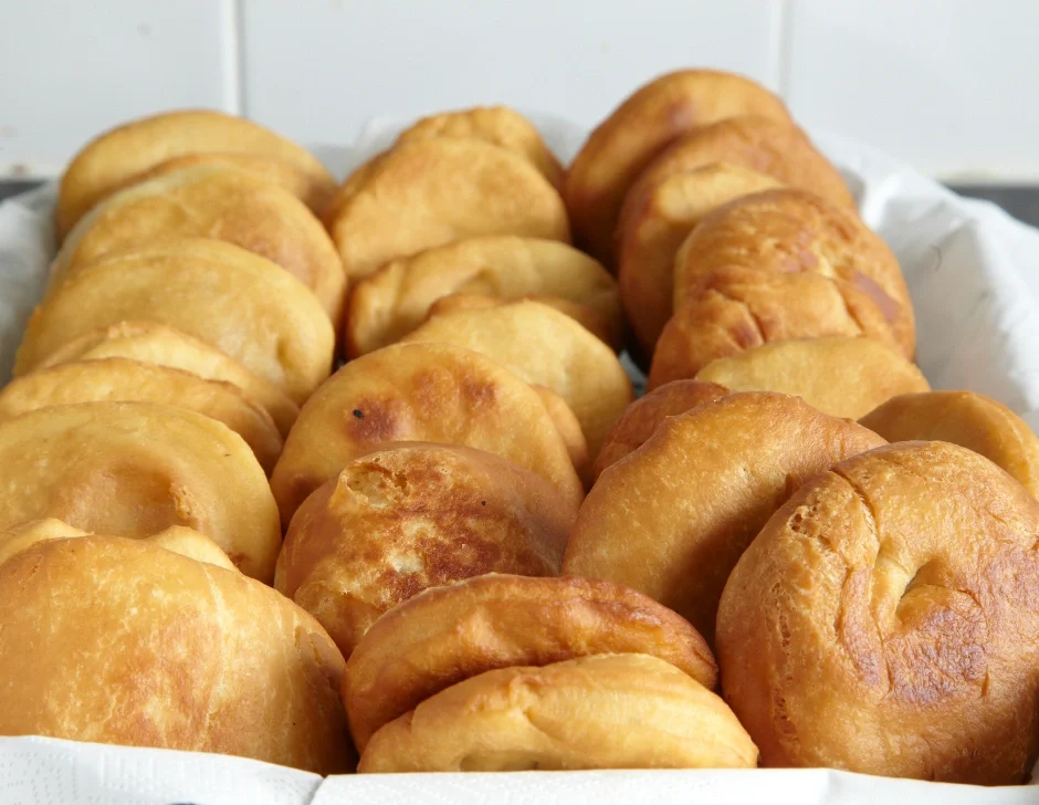 Freshly fried Caribbean bakes stacked in a basket