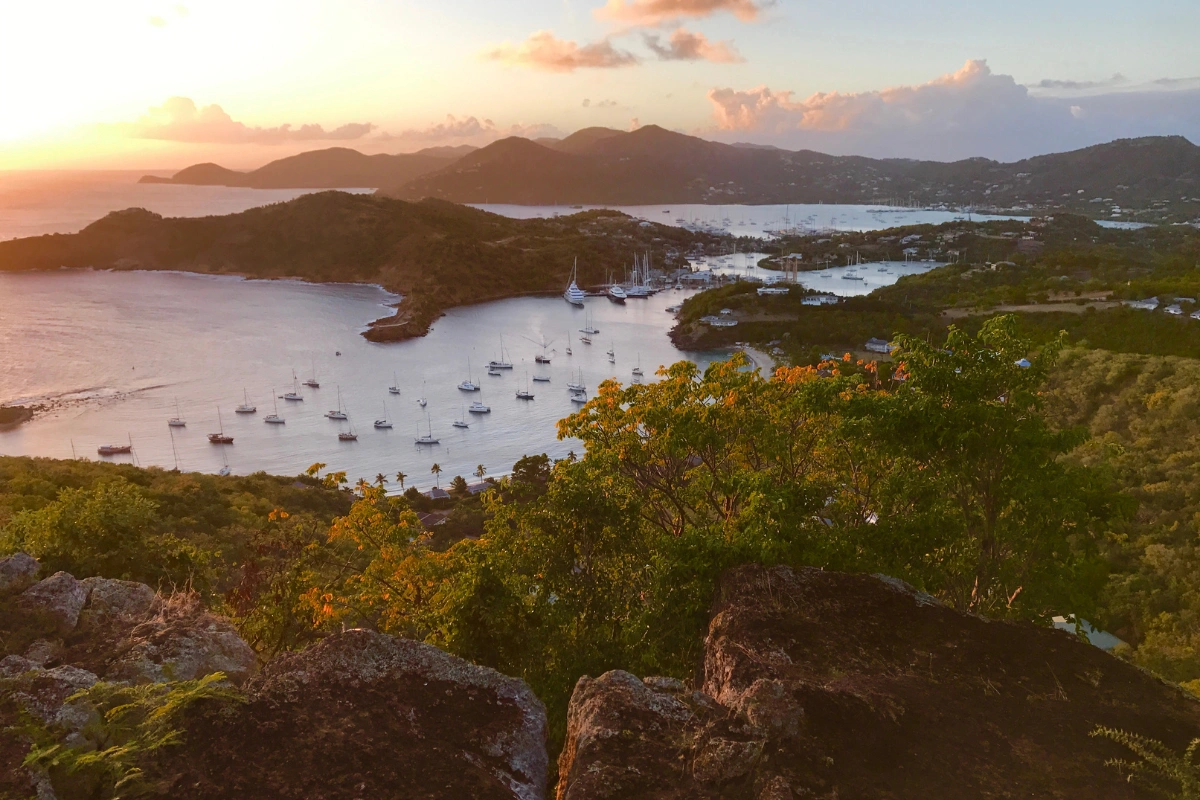 Panoramic view from Shirley Heights overlooking English Harbour, Falmouth Harbour, and anchored sailboats at sunset.