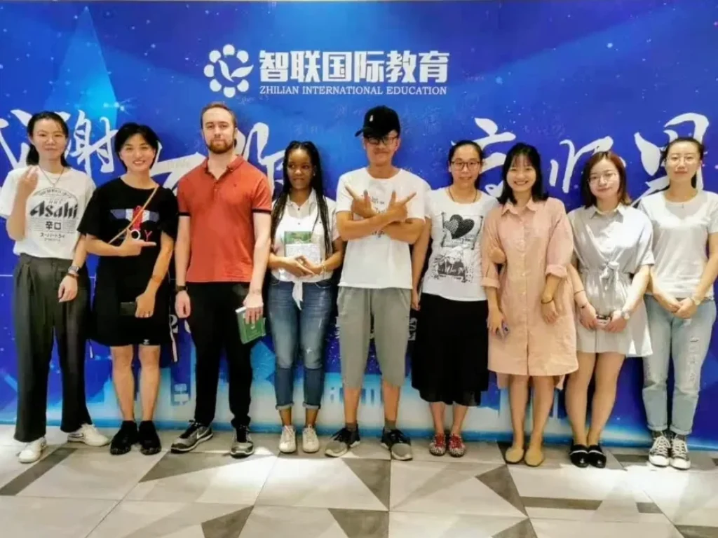 Shelley and Sphenn posing with students in China, where part of the inspiration for Carnival Vibez was shaped