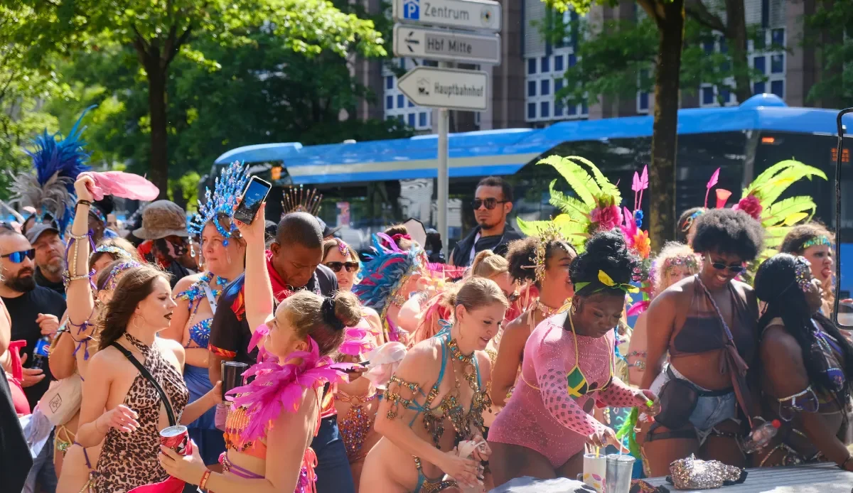 Carnival revelers in colorful costumes celebrating near public transport in Munich during the Munich Carnival festivities