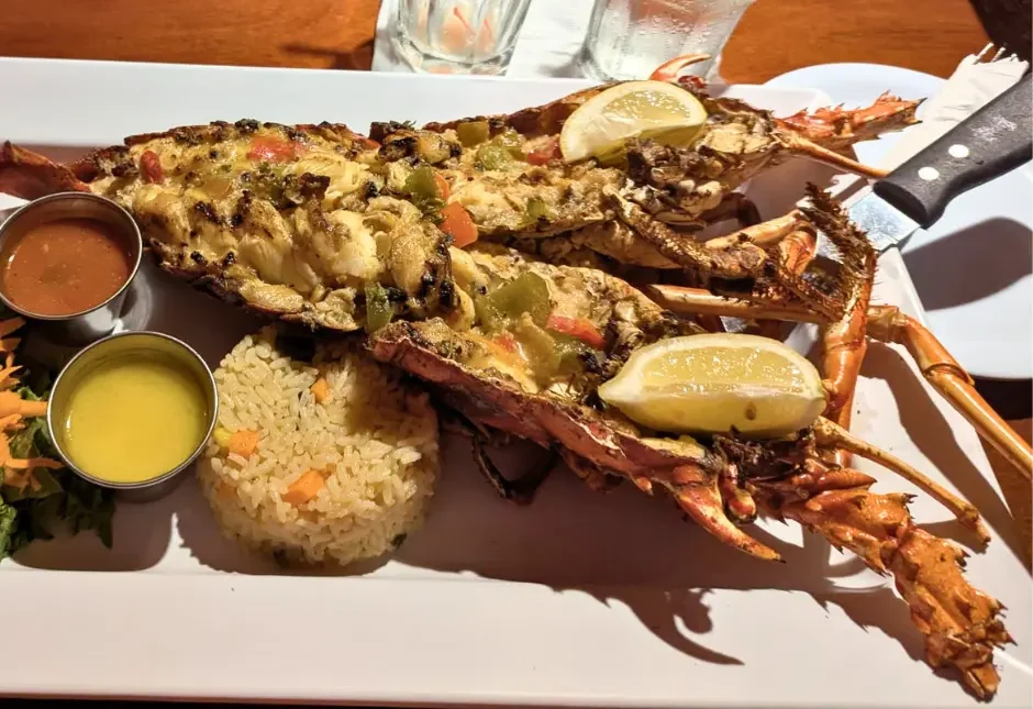 Grilled lobster served with rice, lemon, and sauces during a St. Maarten dining experience around SXM Carnival 2026.