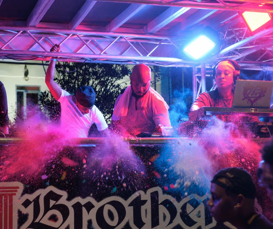 DJs perform on a J’ouvert truck as colorful powder bursts into the crowd during SXM Carnival 2026.