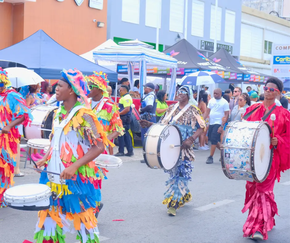 Drummers in colorful costumes perform in the SXM Carnival 2026 parade through Philipsburg, St. Maarten.