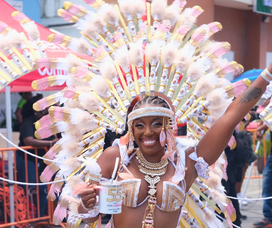 Masquerader in a feathered headdress and jewelled costume on the road during St. Maarten Carnival