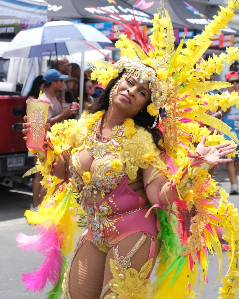 Masquerader in yellow feathered costume enjoying carnival parade, featured as a carnival travel resource