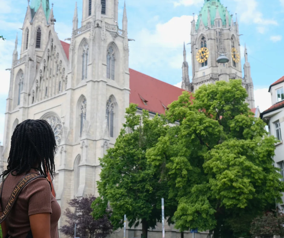 Woman looking up at a historic Gothic church in Munich during carnival weekend 2026