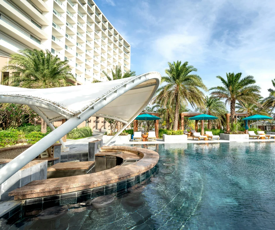 Luxury resort pool with palm trees, representing beach resort stays for Carnival 2026 travelers.