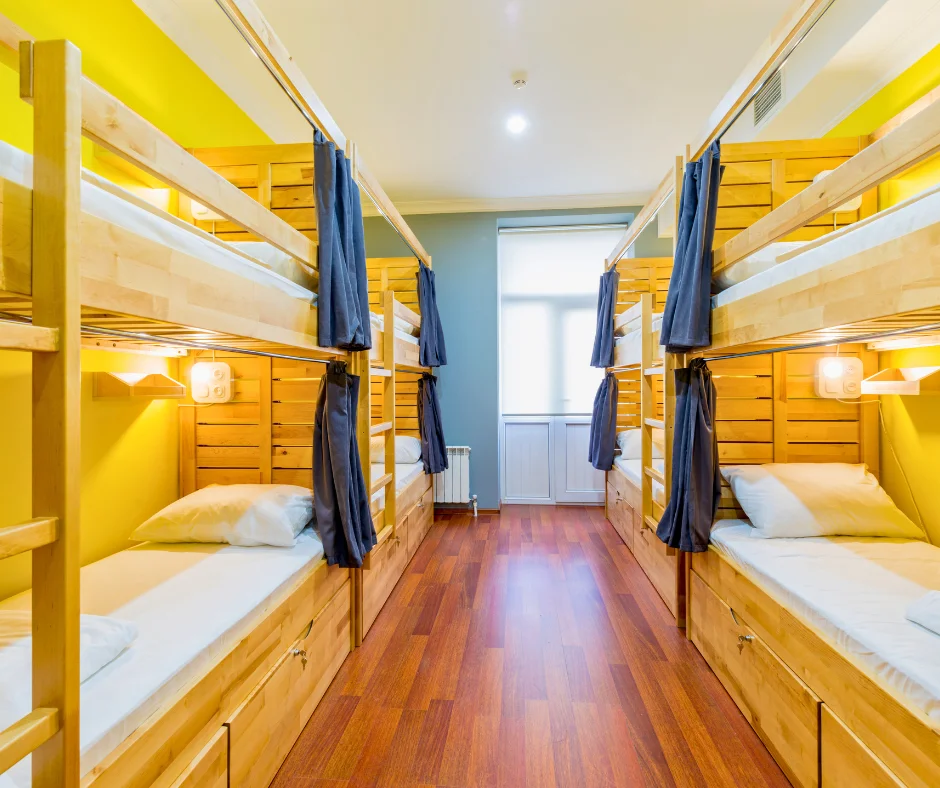 Modern hostel dorm room with wooden bunk beds and privacy curtains for travelers researching where to stay for carnival.