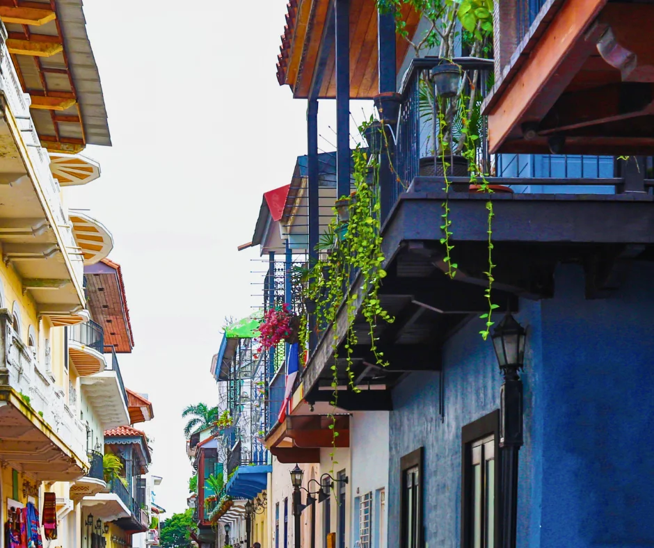 Colorful colonial street with balconies, representing guesthouses and Airbnb stays when deciding where to stay for carnival.