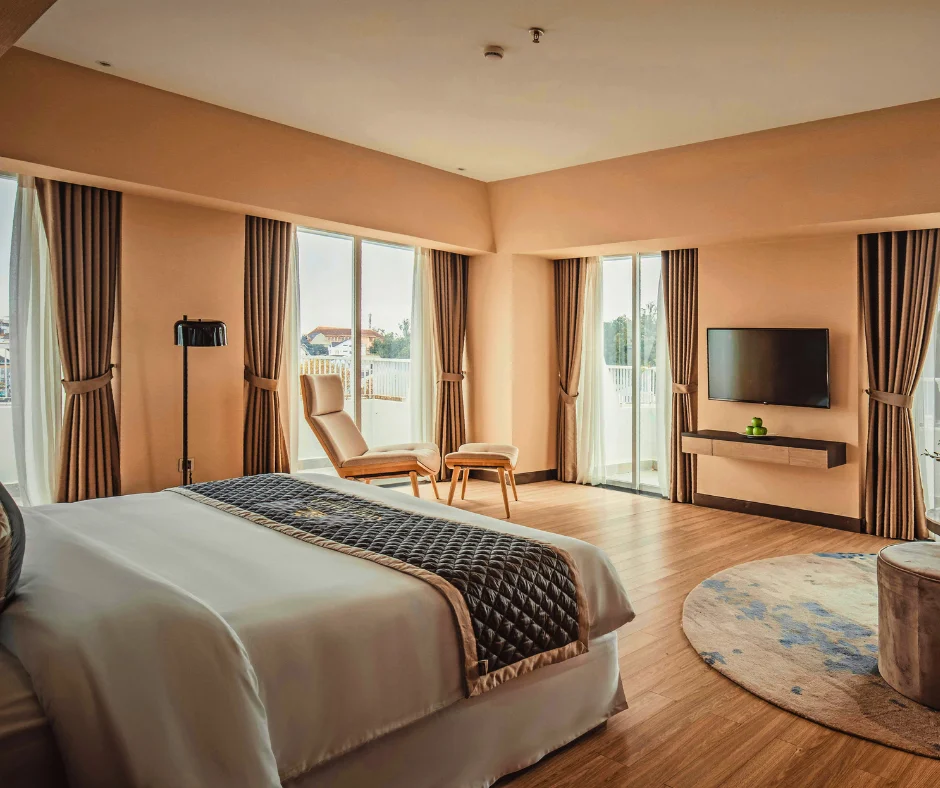 Bright luxury hotel room with balcony doors, representing upscale accommodation for travelers choosing where to stay for carnival.