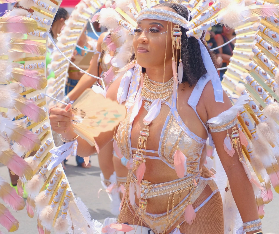 Masquerader in a feathered headdress and jewelled costume on the road during Sint Maarten Carnival