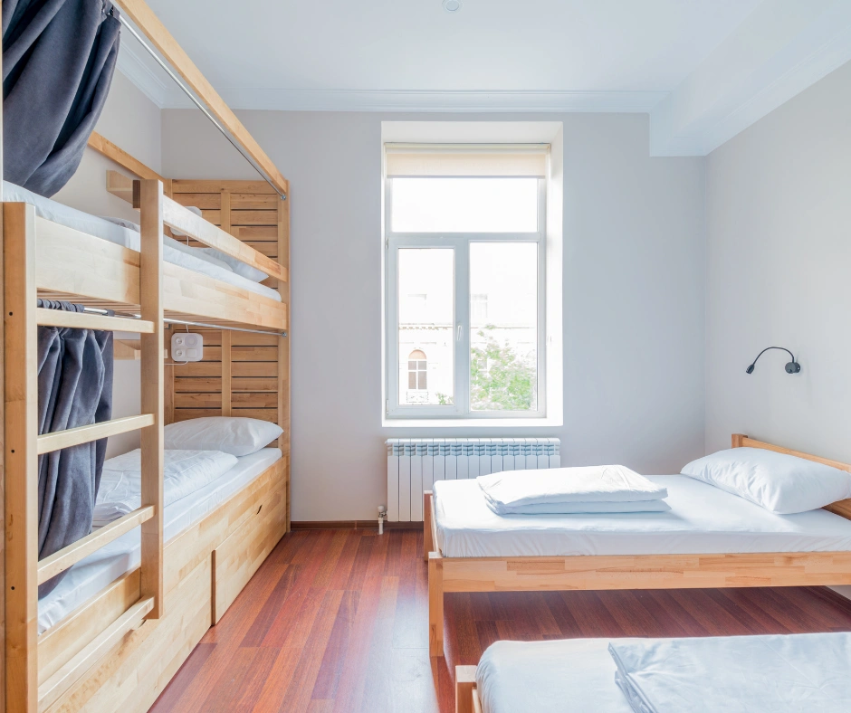 Bright hostel room with bunk beds and shared sleeping space, representing an affordable USA hostel option for where to stay for carnival.