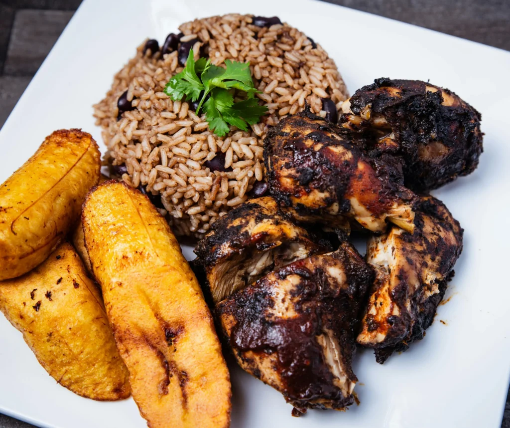 Jerk chicken with rice and peas and fried plantains, a popular example of Caribbean foods at carnival
