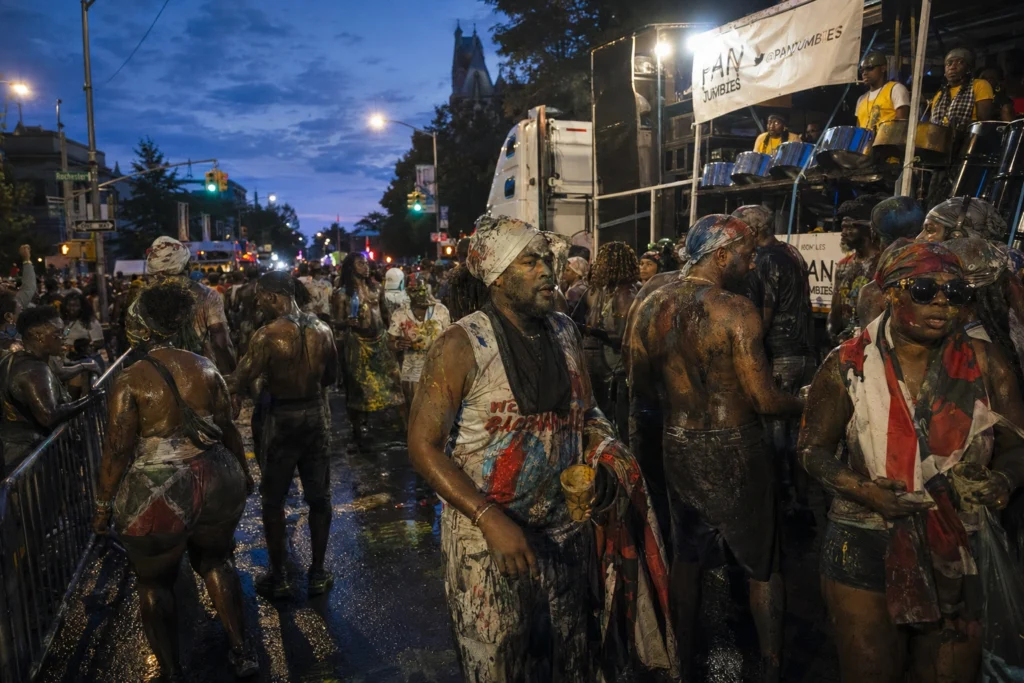 J’ouvert revelers covered in paint dancing near Eastern Parkway during Brooklyn Carnival celebrations