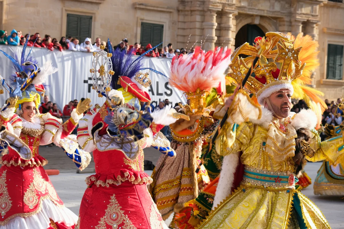 Elaborately costumed performers dancing at Malta Carnival in Saint George's Square Valletta