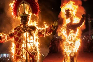 Costumed mourners in black lace veils carry an ornate coffin through the streets of Barranquilla during the Burial of Joselito Carnaval