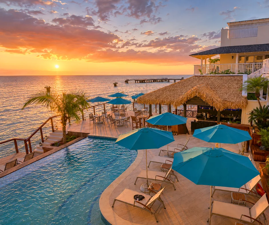 Sunset over the infinity pool and thatched bar at Fort Young Hotel on the Roseau seafront, a top choice among Dominica Carnival hotels.