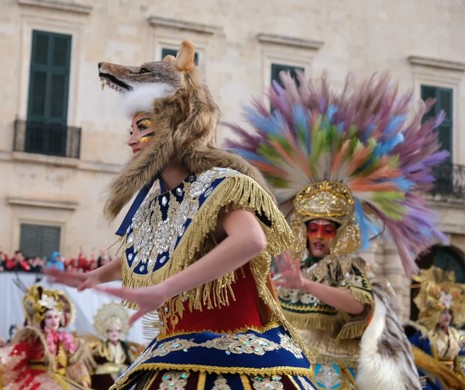Malta Carnival dancer in a wolf headdress and jewelled costume performing in Valletta