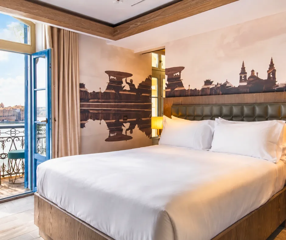 Iniala Valletta Room with a balcony and Valletta skyline mural at one of the splurge hotels for Malta Carnival