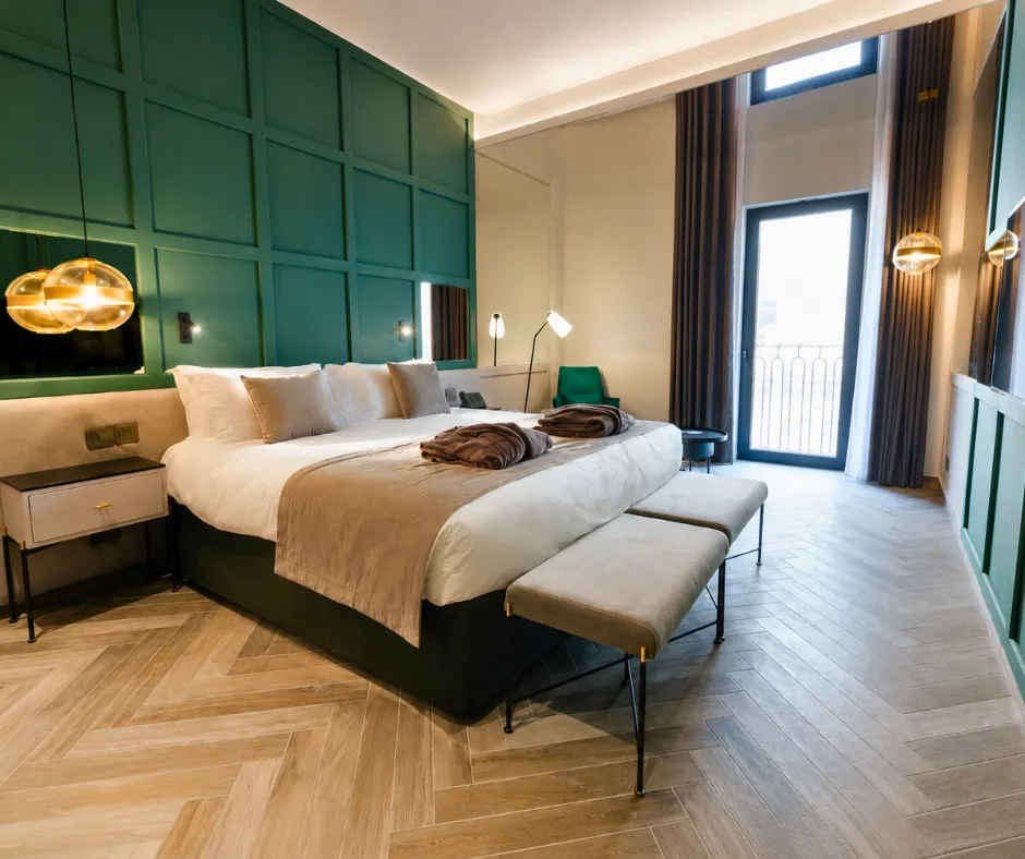 Modern room with green panelling and a balcony at The Embassy Valletta Hotel