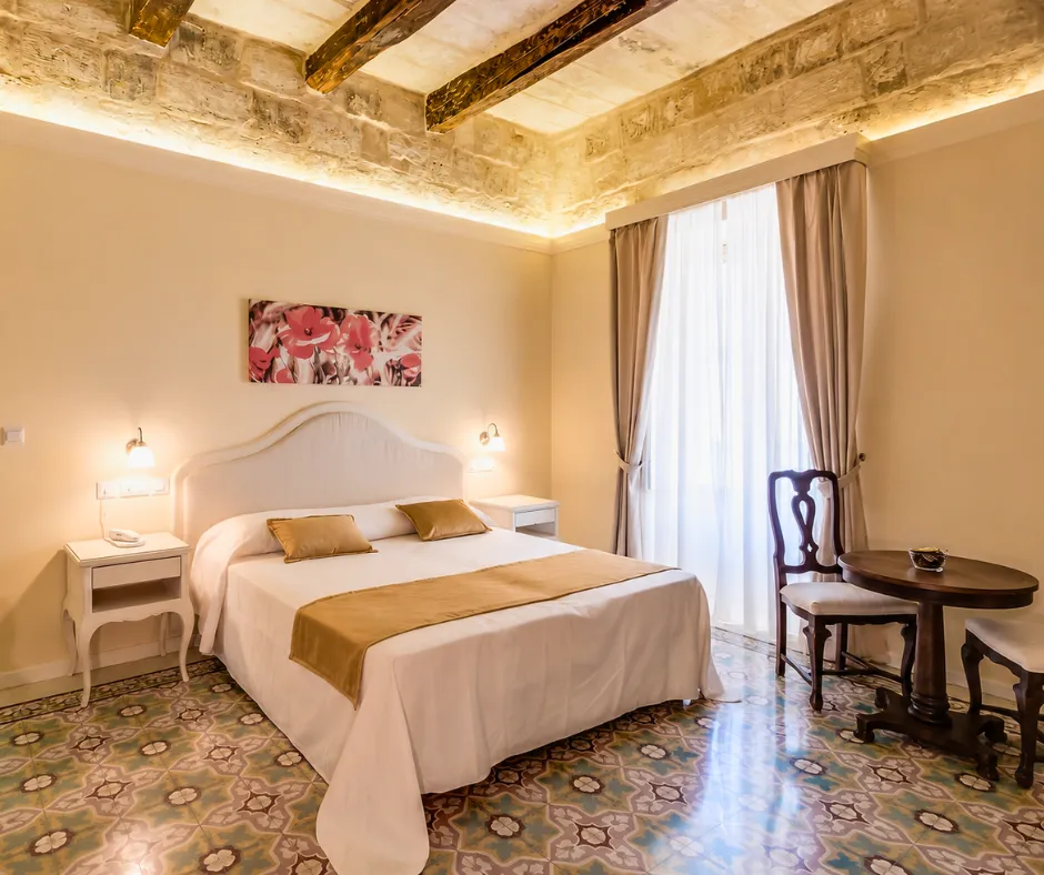 Traditional room with patterned floor tiles and beamed ceiling at Tano's Boutique Guesthouse in Valletta