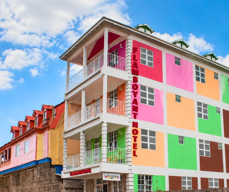 Brightly painted multicoloured façade of La Flamboyant Hotel on King George V Street, one of the Dominica Carnival hotels right on the parade circuit.