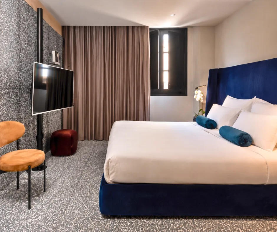 Guest room with a navy velvet headboard and terrazzo finishes at Rosselli AX Privilege in Valletta