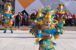 Dancer in a blue and gold feathered costume performing at Malta Carnival, with Valletta hotels a short walk from the parade route