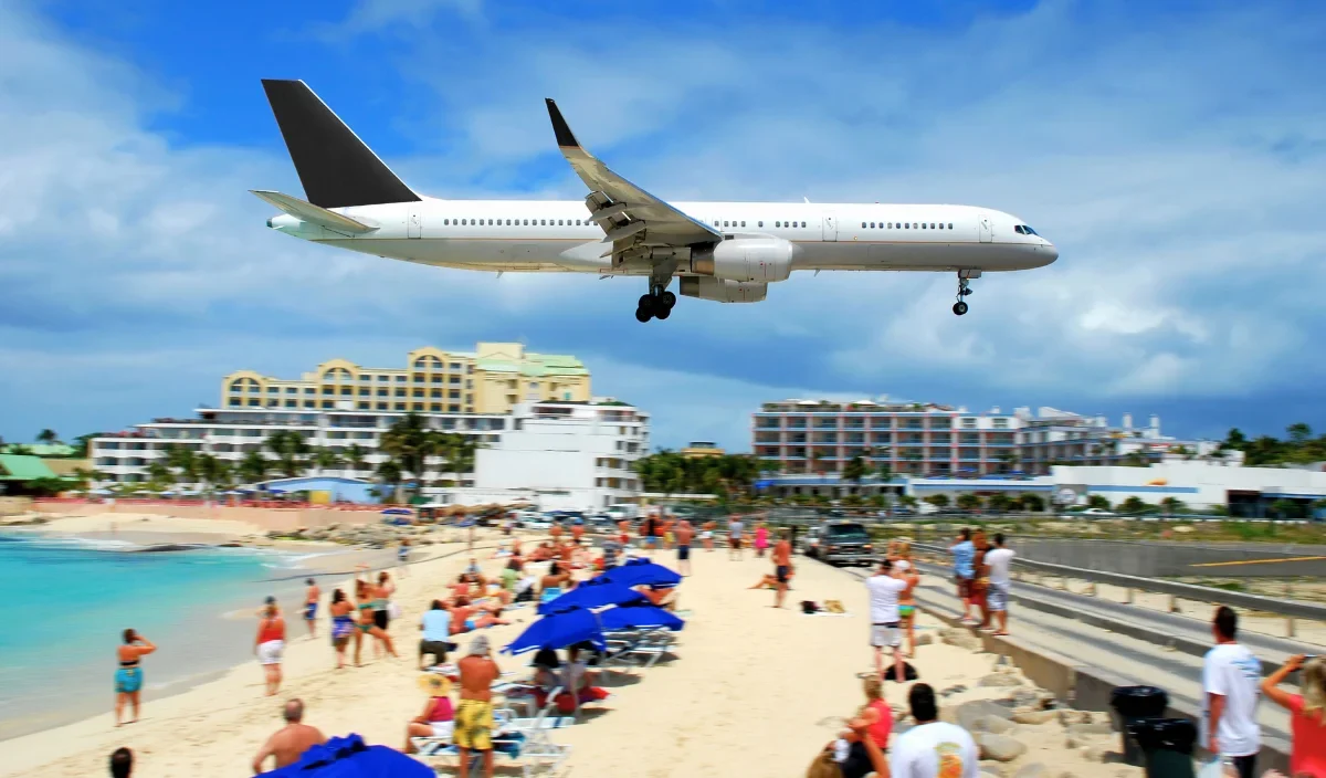 Airplane landing over Maho Beach in Sint Maarten near hotels and resorts for SXM Carnival visitors