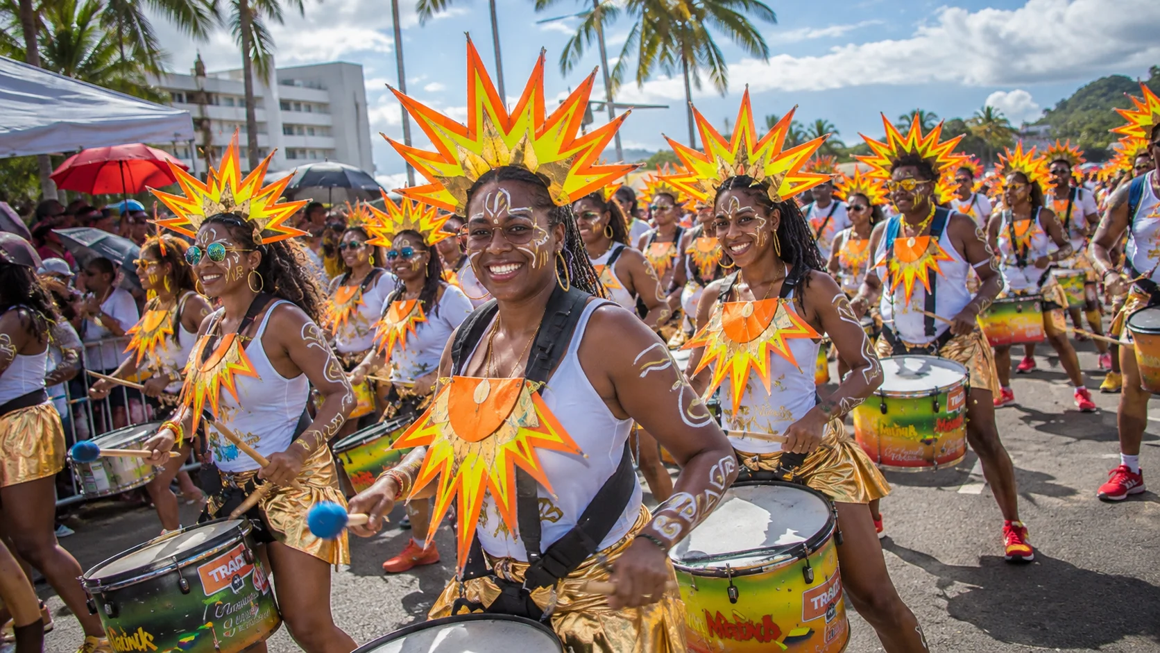 Drummers in orange and yellow sun headdresses playing through the streets of Fort-de-France at Martinique Carnival, one of the Caribbean Carnivals 2027