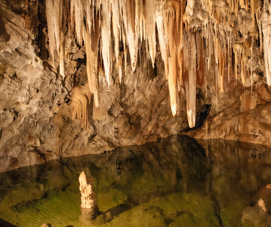 Limestone stalactites hanging above a still underground pool inside Harrison's Cave in Barbados.