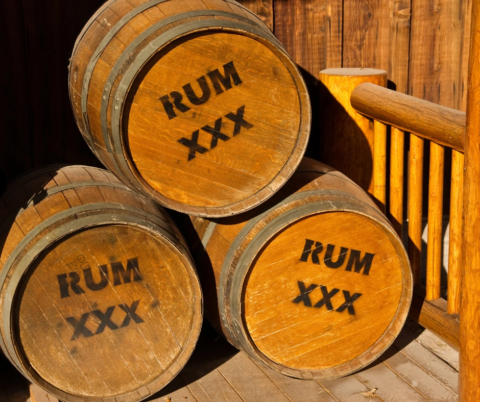 Wooden rum barrels stacked together during a rum distillery tour in Barbados.