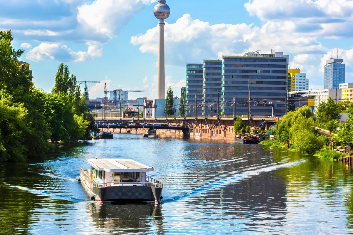 Tour boat cruising the River Spree with the Berlin TV Tower rising above the city skyline