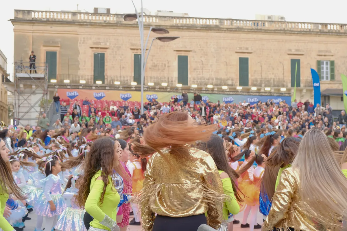 Young dancers in sequinned costumes performing at the Children's Carnival in Valletta